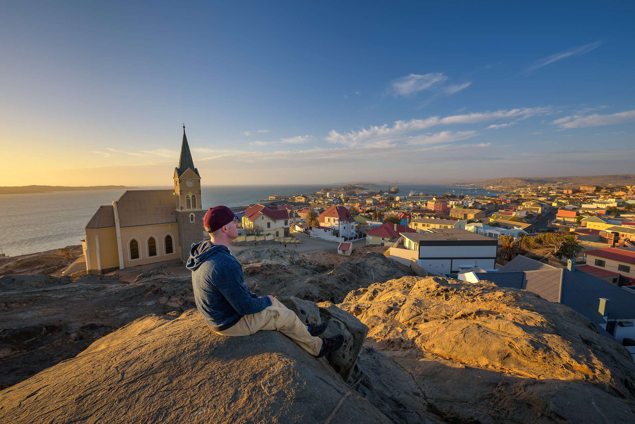 A tourist enjoys the sunset view of Luderitz in Namibia