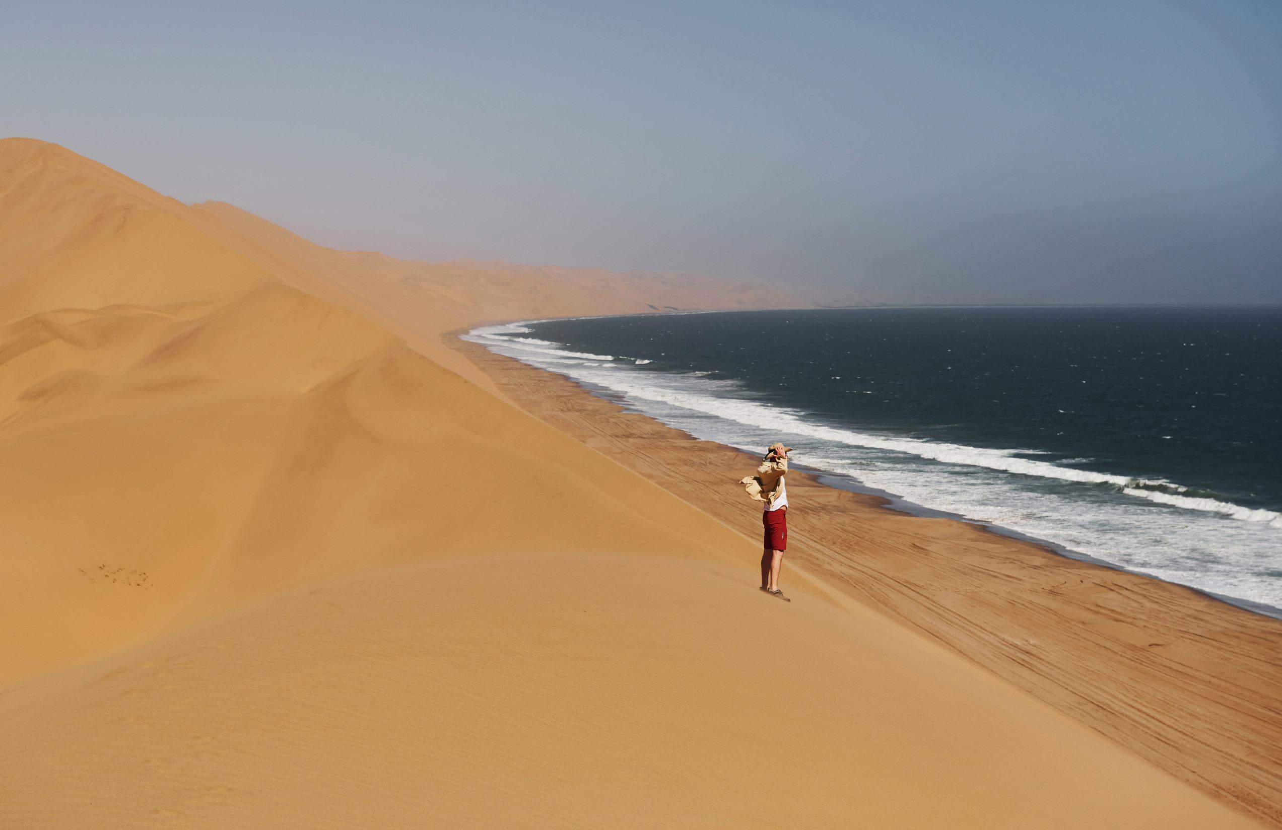 A tourist standing by the sea at Sandwich Harbour