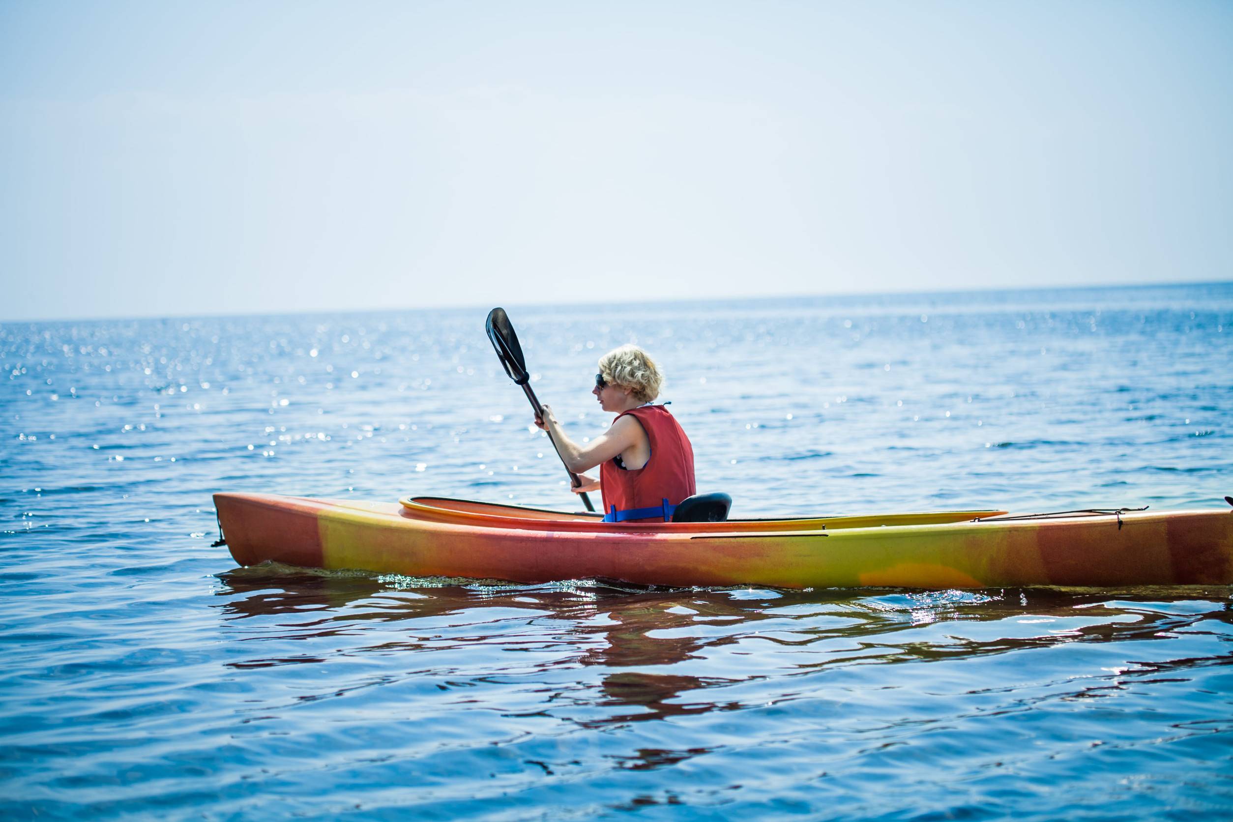 A woman kayaking alone in the sea