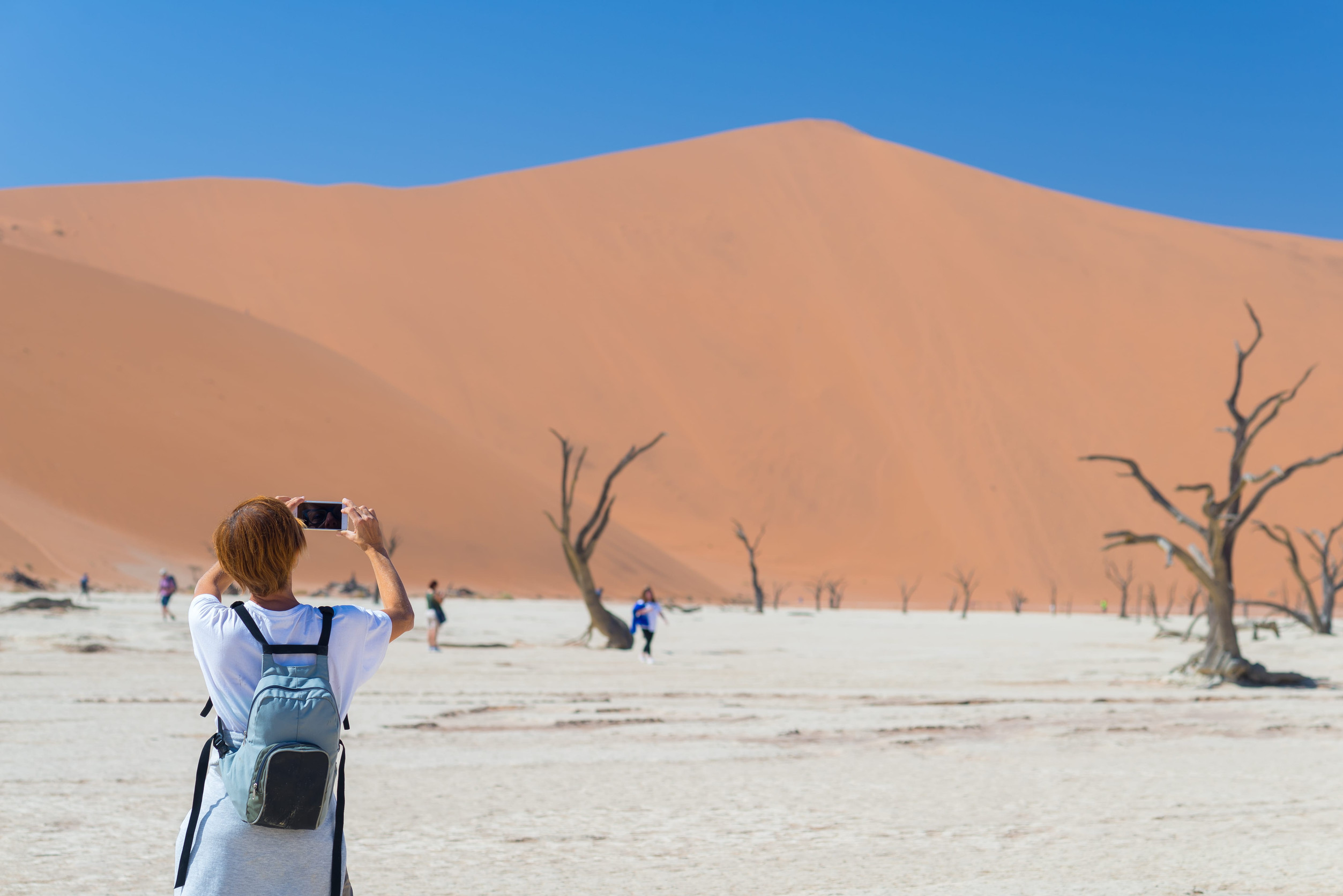 A tourist clicking a picture of the sand dunes at the Namib Desert