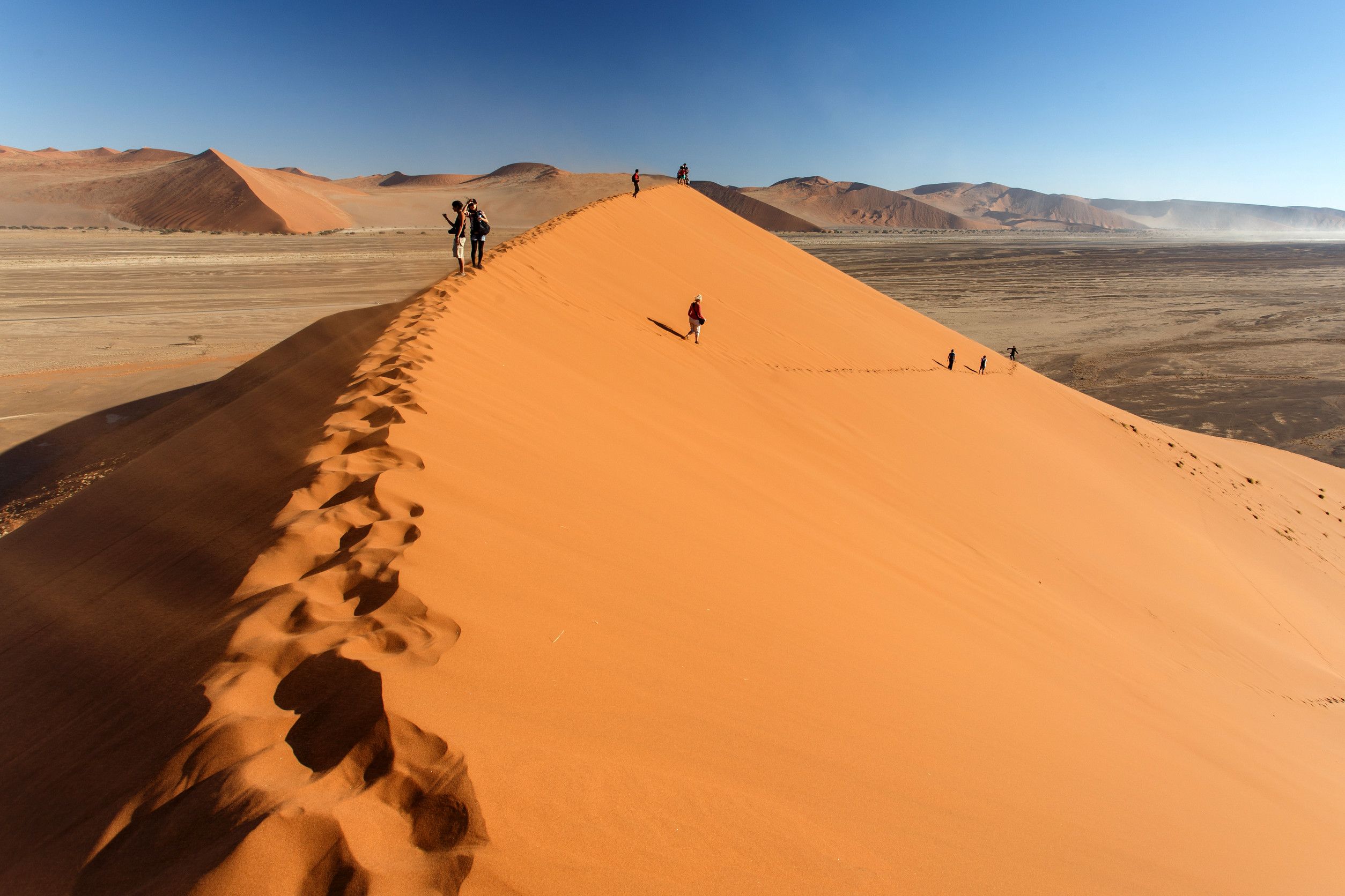 Tourists walking up a Sand Dune